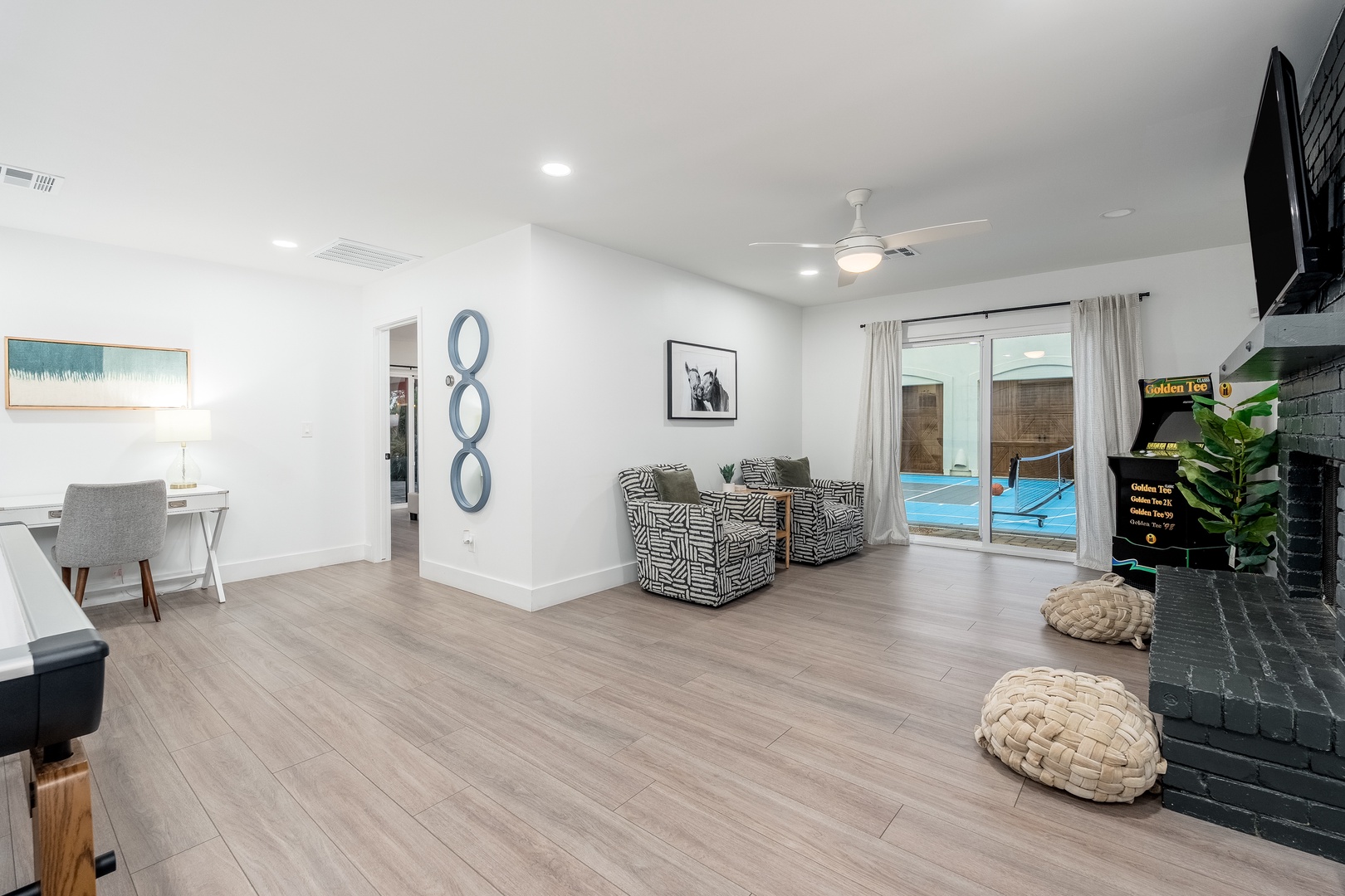 Relax in your spacious living area with modern décor, sleek floors, and direct pool access. Unwind on comfy seating or work at the desk—your bright, airy retreat awaits.