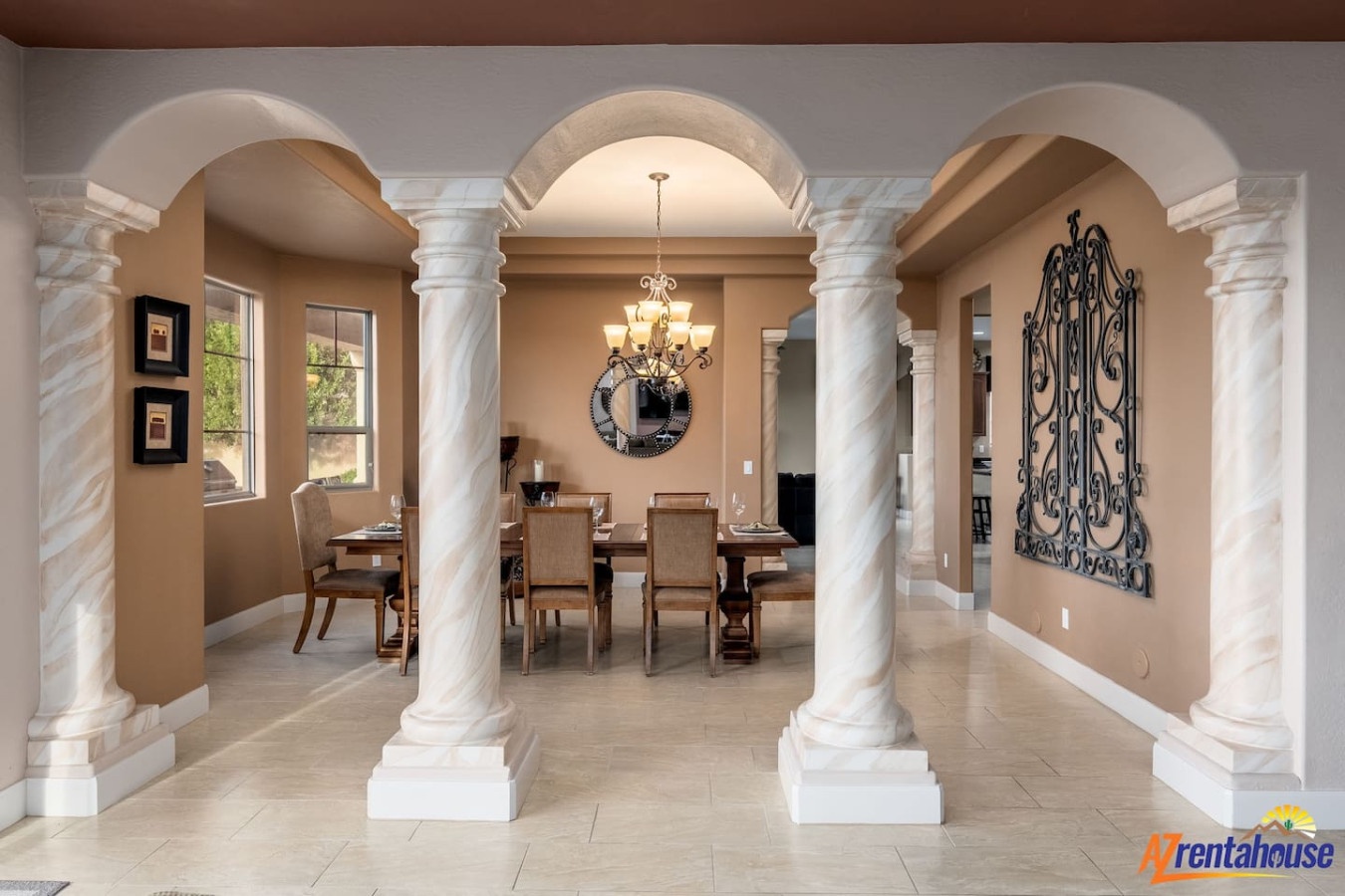 Step into your elegant dining space where marble columns frame intimate meals under a stunning chandelier.