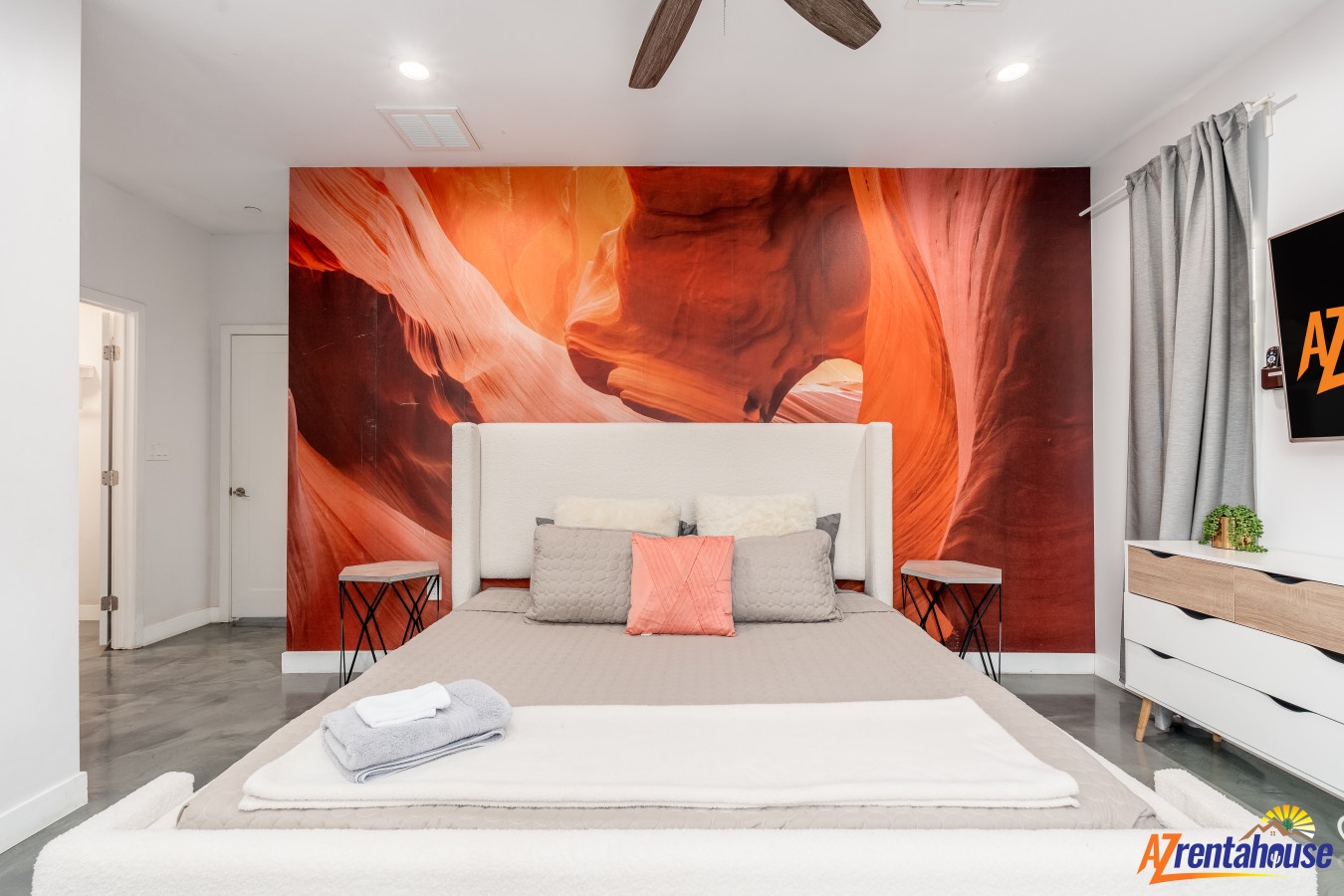 Unwind in your stylish bedroom featuring a stunning canyon mural, plush bedding, and modern amenities for ultimate comfort.