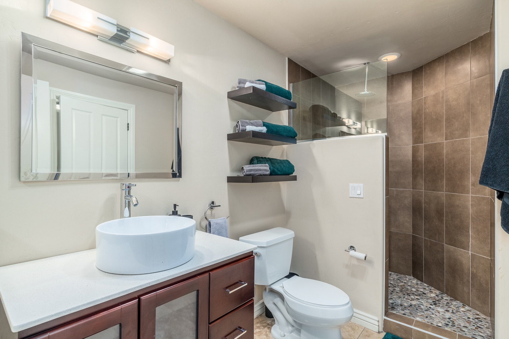 Step into your private oasis with modern fixtures, a spacious walk-in shower, and thoughtfully arranged towels ready for your arrival.