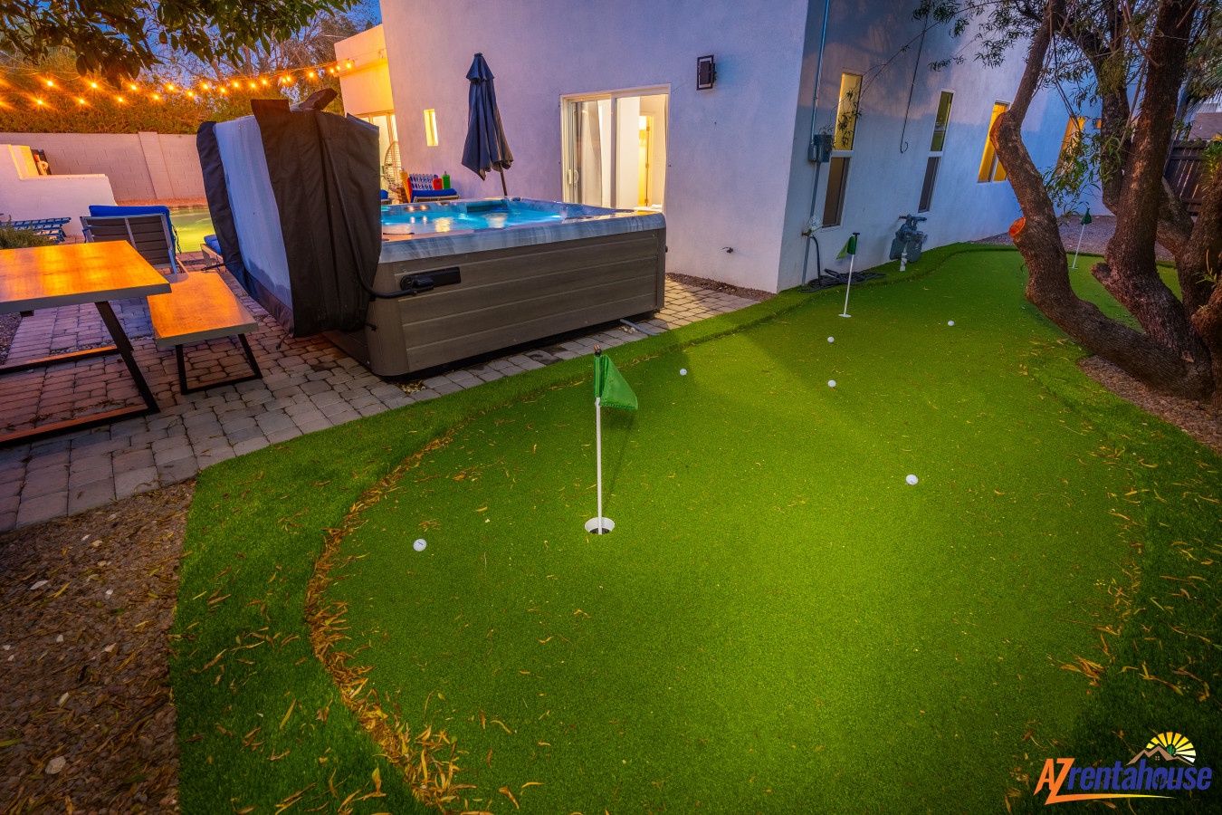 Practice your putting while soaking up the evening ambiance in your private backyard oasis with hot tub and string lights.