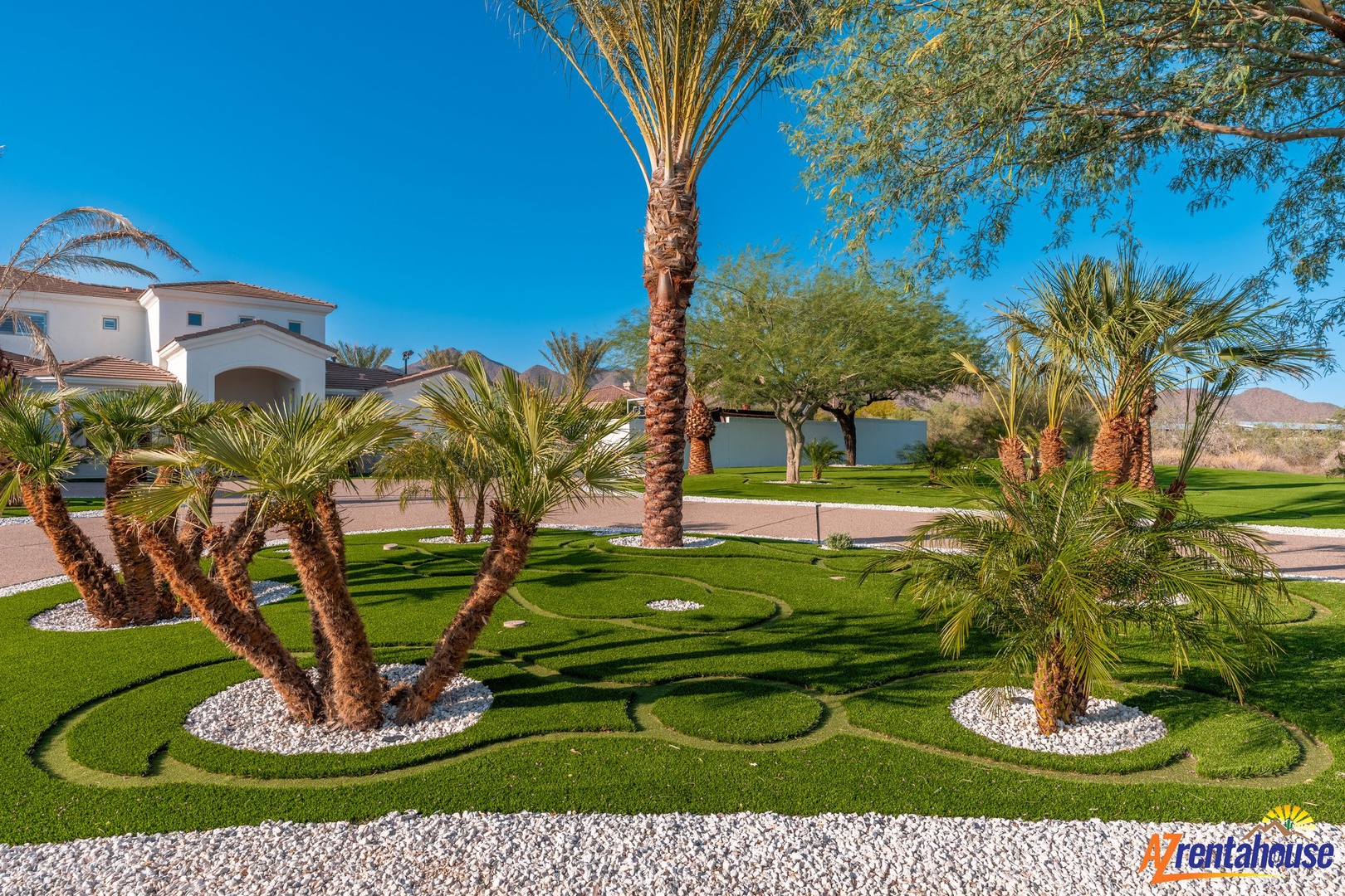 Beautifully manicured tropical landscape with palm trees and pristine grass surrounds this desert resort property.