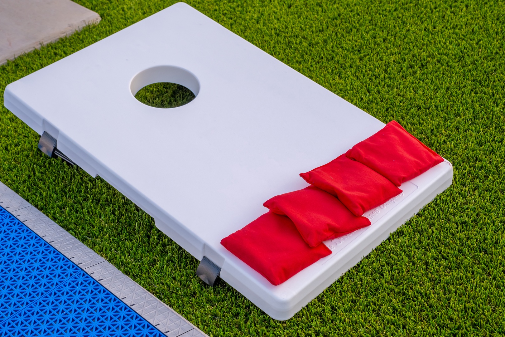 A cornhole board ready for your friendly backyard games, set on lush green grass for classic outdoor fun and competition.