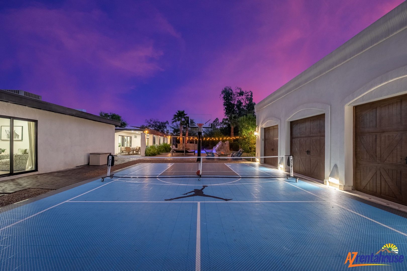 Private sport court illuminated beneath dramatic purple skies, creating an inspiring backdrop for evening recreation.