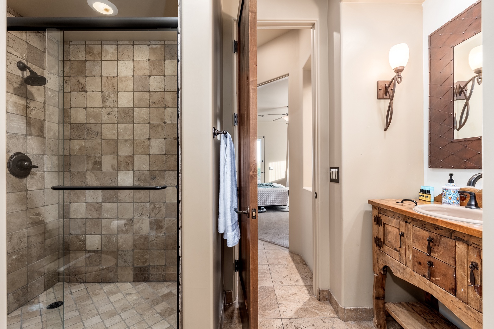 Step into your private retreat with a spacious glass-enclosed shower and charming rustic vanity—mountain-chic meets modern comfort in every detail.