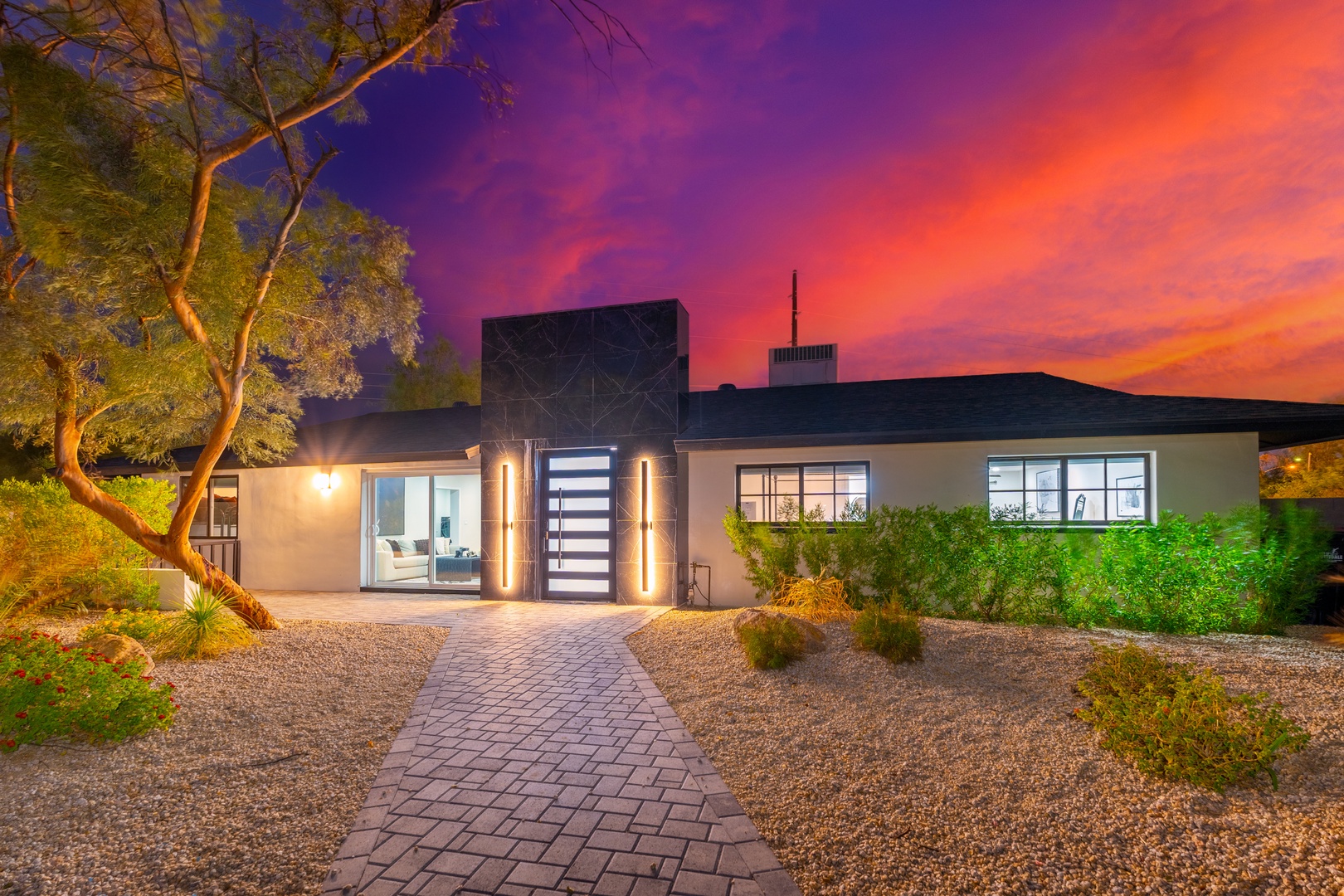 Modern desert retreat framed by stunning twilight skies and desert landscaping, offering a warm welcome at day's end.