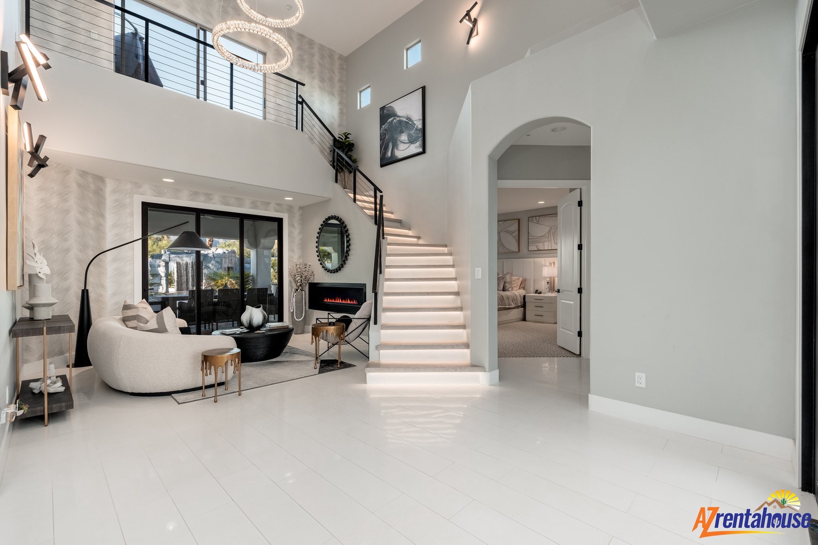 Step into your stunning two-story sanctuary featuring soaring ceilings, elegant modern furnishings, and sparkling chandeliers that create the perfect atmosphere.