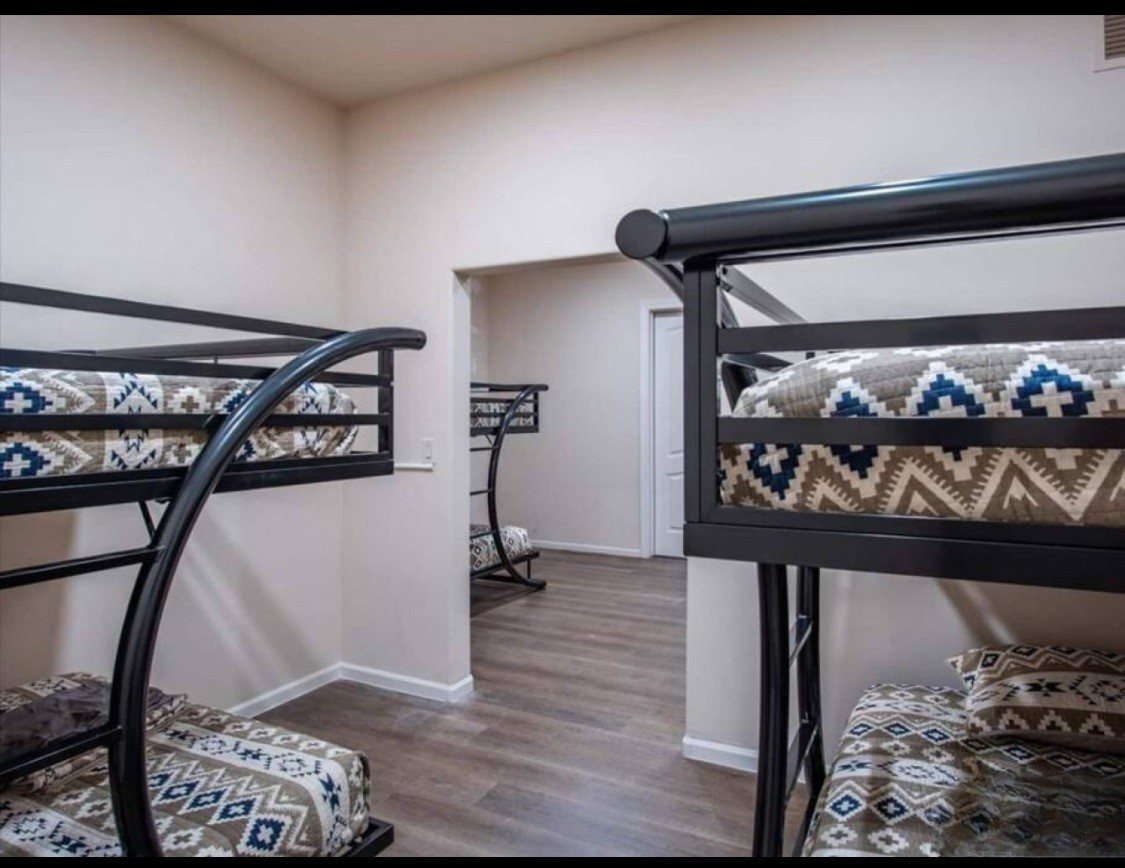 Your group will love this spacious bunk room with stylish geometric bedding and modern black metal frames—perfect for kids or friends sharing cozy memories together.