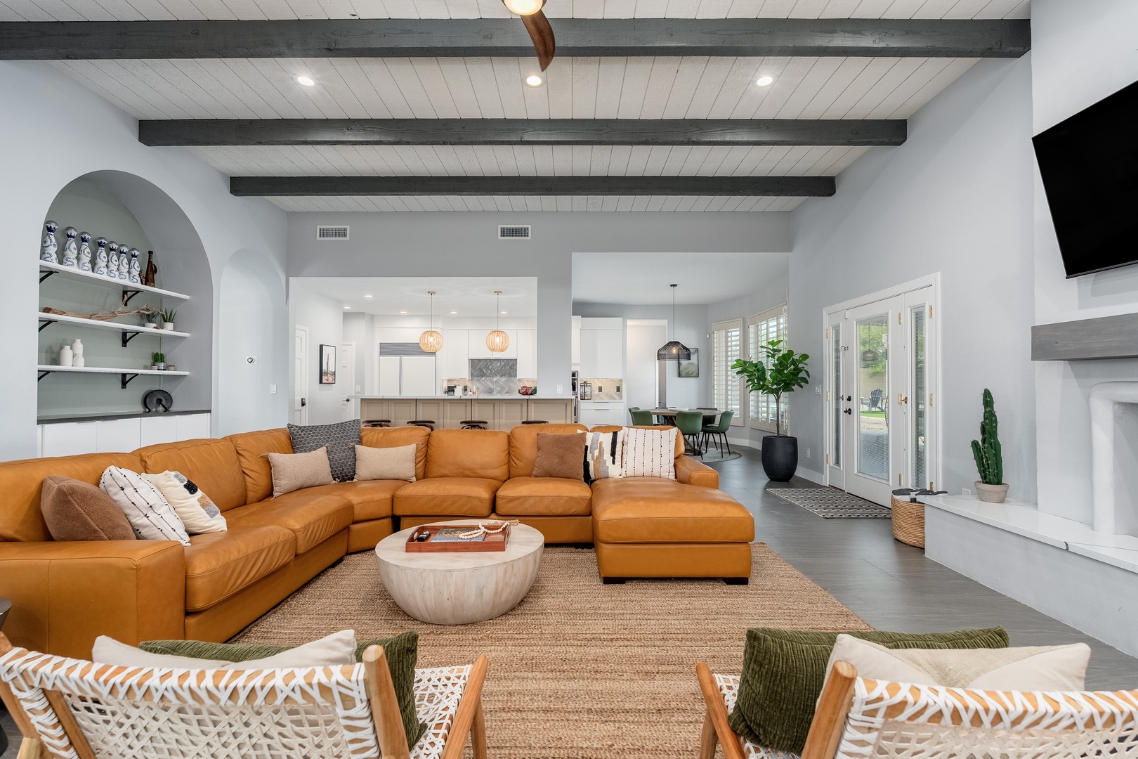 Unwind in your stylish open-plan living space, where soaring wood-beamed ceilings and plush leather seating invite you to relax after a day of adventure.