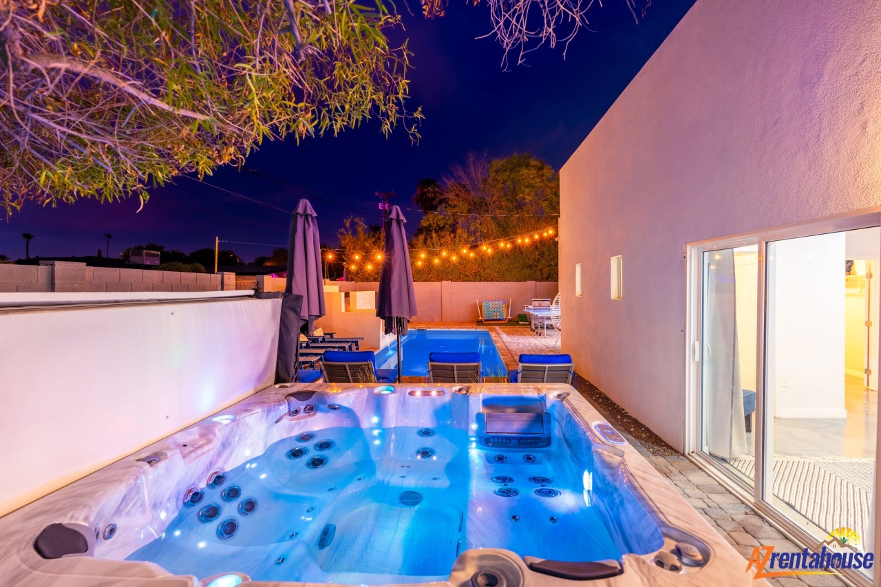 Soak in your private hot tub under starlit skies, with the pool glowing softly nearby and string lights creating magical ambiance.