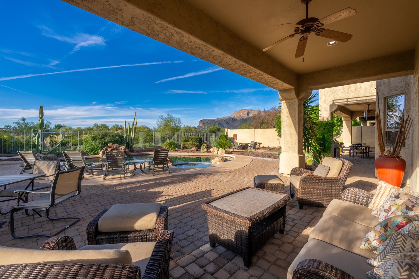 Lounge on comfy wicker chairs beneath your covered patio, where ceiling fans keep you cool as you gaze at the desert landscape and sparkling pool framed by mountains and saguaro cacti.