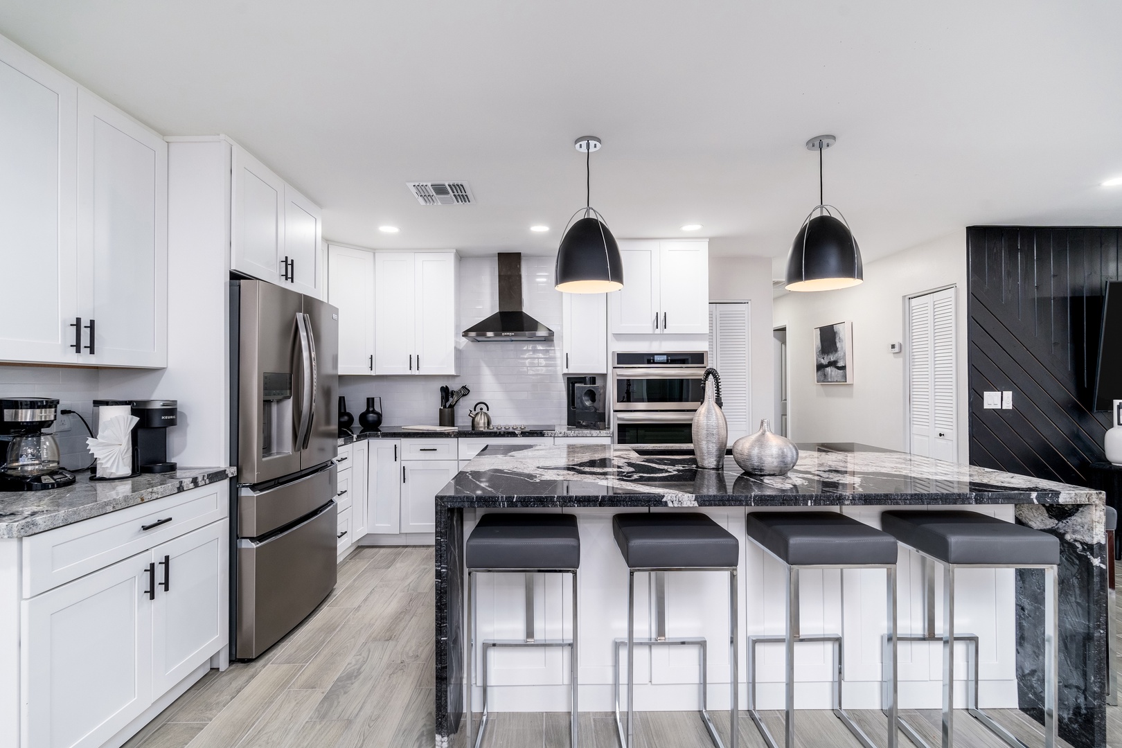 Your gourmet kitchen features crisp white cabinetry, gleaming granite counters, stainless appliances, and a spacious island with seating—perfect for preparing memorable meals and gathering with loved ones.