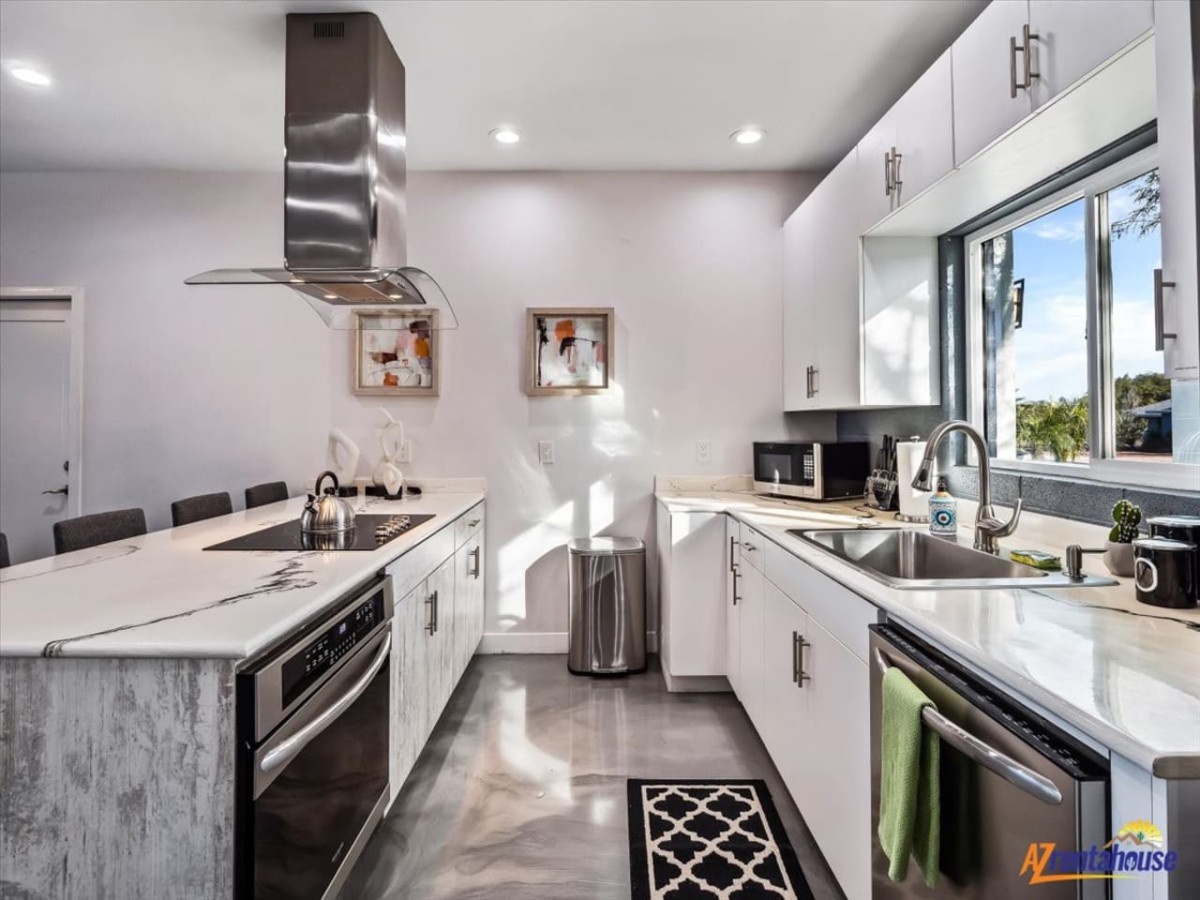 Step into your gourmet kitchen featuring gleaming white cabinets, granite counters, and premium stainless steel appliances for memorable culinary moments.