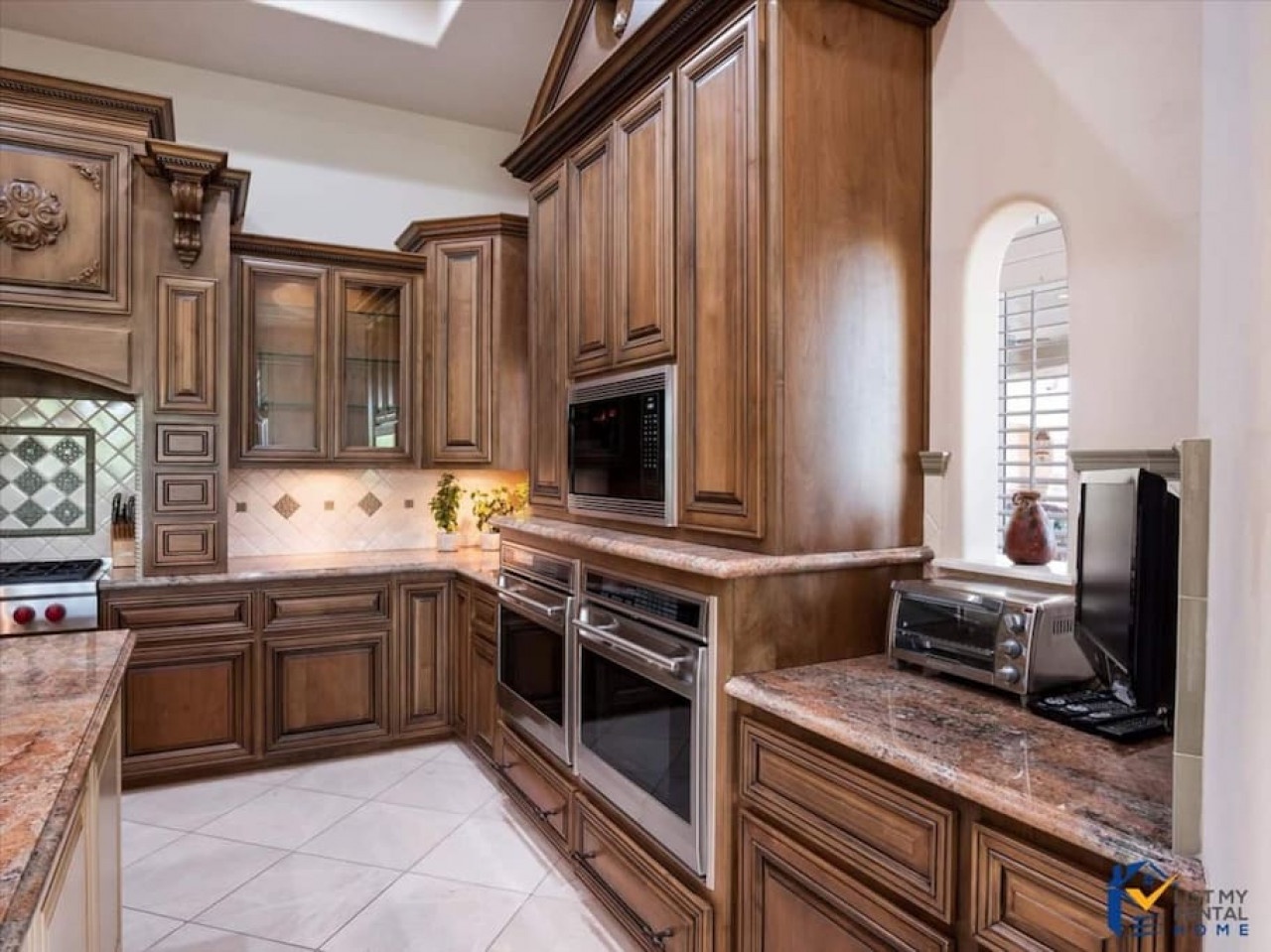 Your gourmet kitchen features rich wood cabinetry, granite counters, and premium appliances for creating memorable meals.