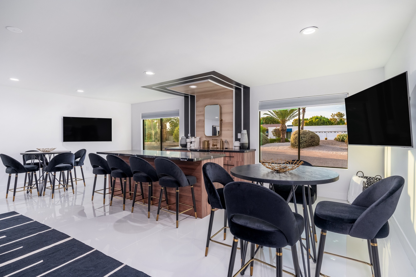 Gather with your group in this sleek, modern lounge space featuring a stylish bar, high-top seating, and dual TVs—perfect for socializing, sipping cocktails, or catching the game together.