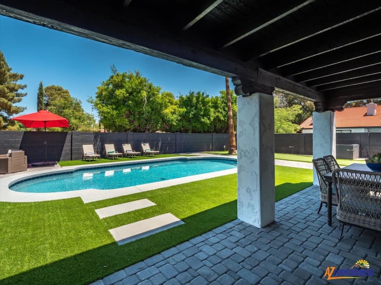 Step onto your private covered patio where comfortable seating awaits beside the sparkling pool and manicured lawn.