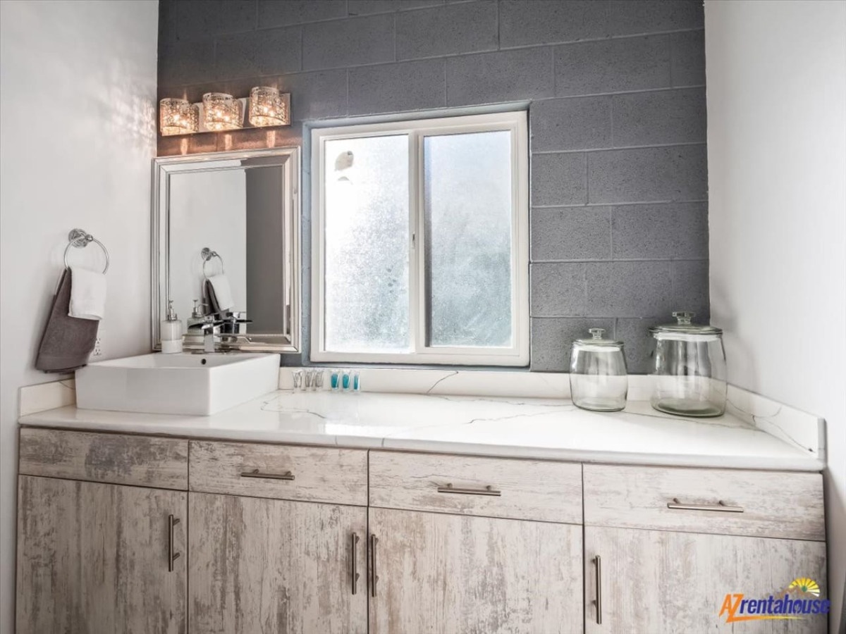 Unwind in your spa-inspired bathroom with elegant vanity lighting and natural garden views through your private window.