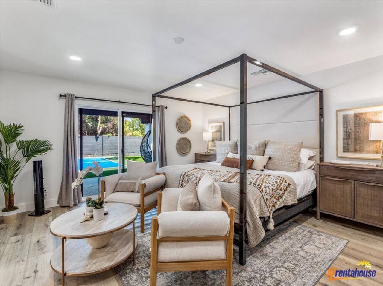 Wake up in your stylish canopy bed suite with poolside views through floor-to-ceiling windows and relax in the cozy seating area.