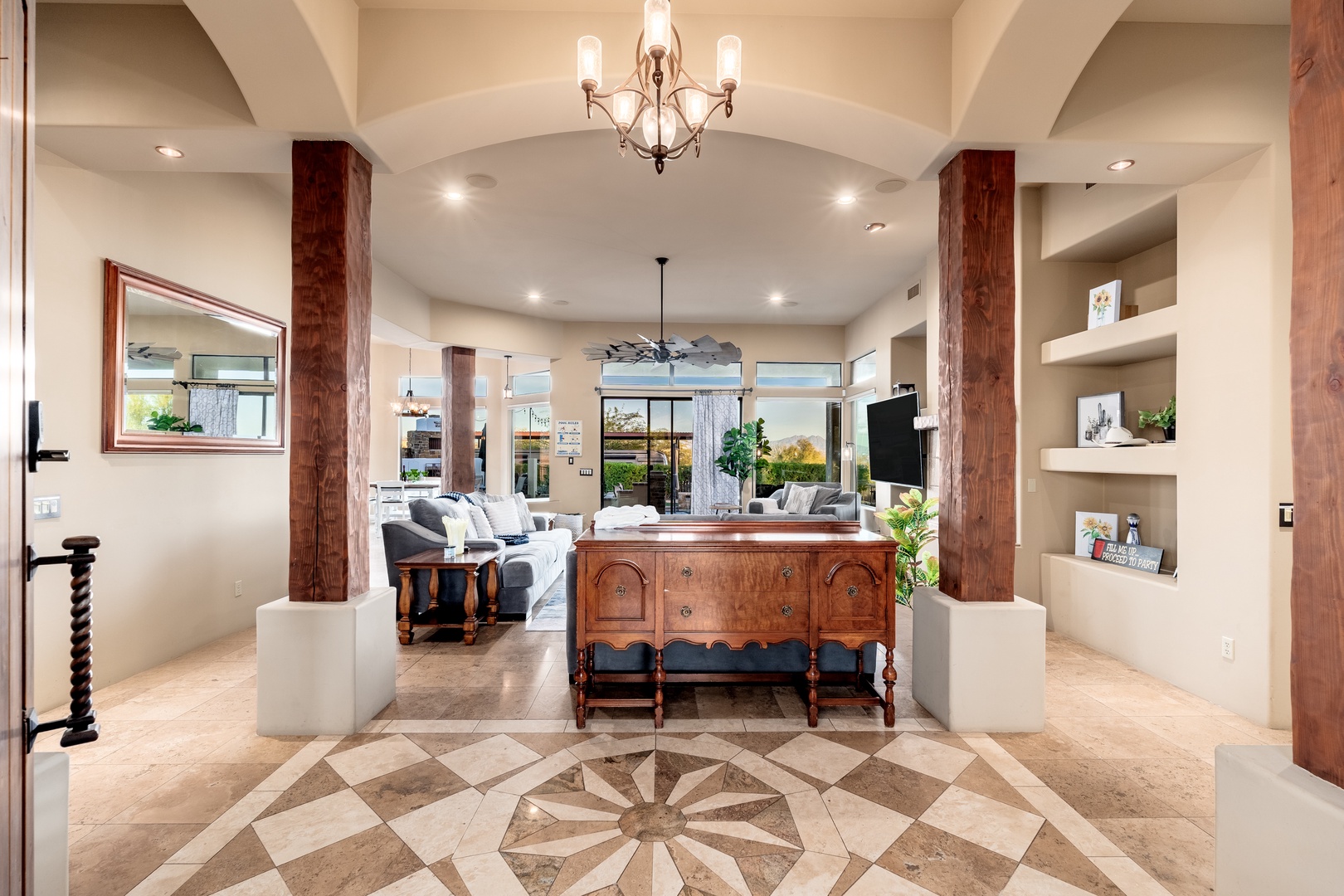 Step into an inviting entryway where soaring vaulted ceilings, warm wooden beams, and elegant tile work welcome you home. Natural light floods the open layout, revealing cozy living spaces and lush outdoor views that beckon you to unwind.