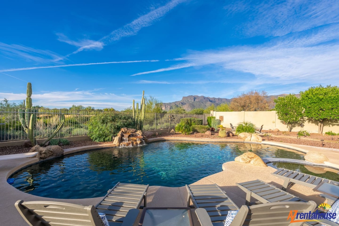 Dive into your private desert oasis with stunning mountain views, natural rock waterfall, and sunny poolside lounging under Arizona's endless blue skies.