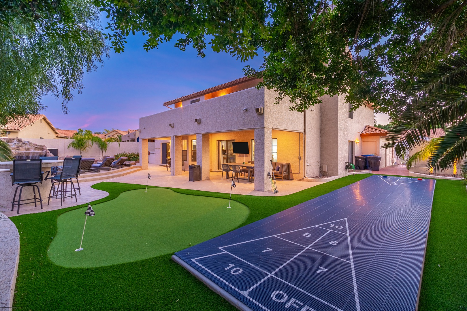 This property features a spacious backyard with a miniature putting green, shuffleboard court, and covered patio area—offering resort-style amenities in a tranquil neighborhood setting.