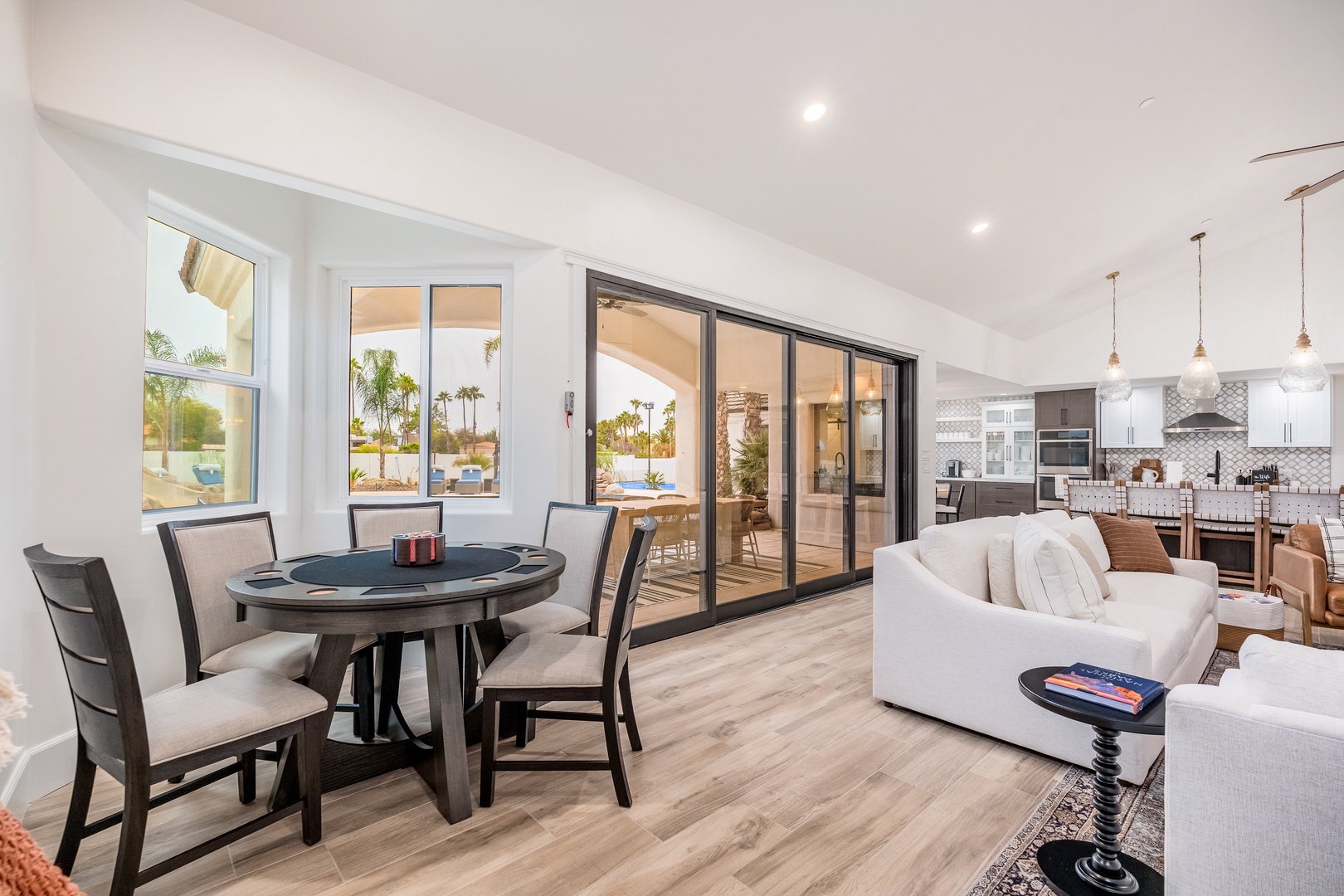 Step into your bright, open-concept living space where sunlit windows frame tropical palms and the dining area flows seamlessly into a fully equipped kitchen—perfect for gathering and creating vacation memories together.