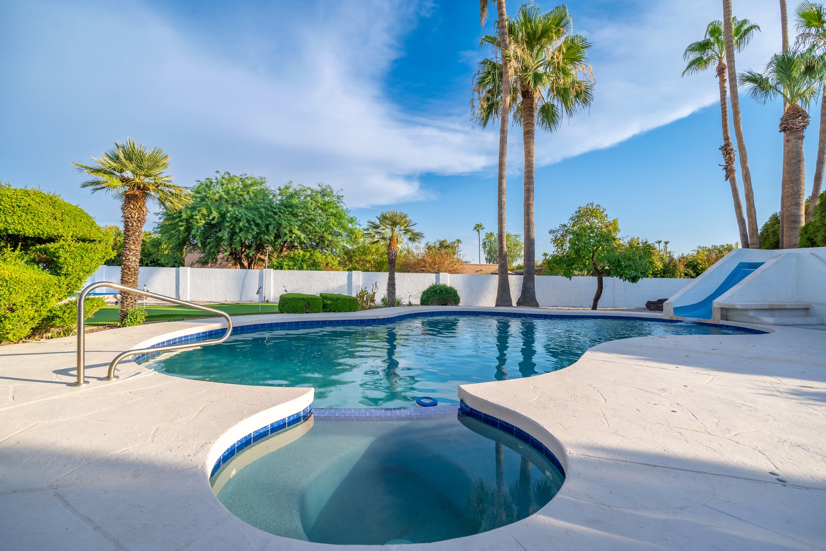 Unwind in your private pool oasis, surrounded by swaying palms and sunny skies, with a separate hot tub for ultimate relaxation after exploring the desert.