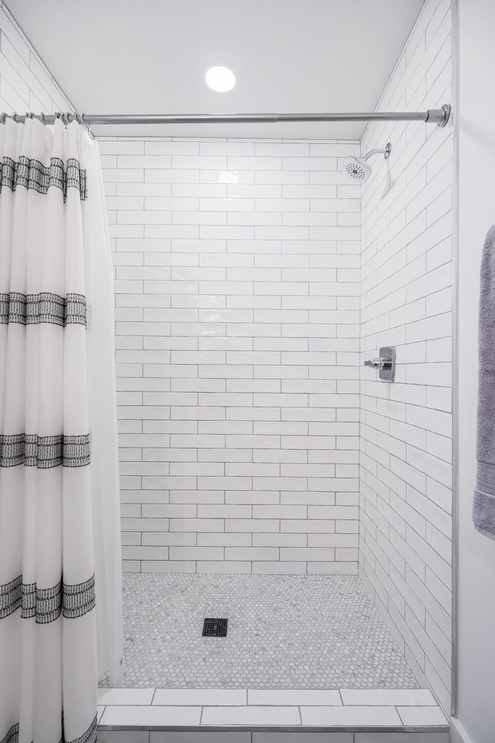 Step into this bright, spa-like shower with crisp white subway tile and a modern rainfall showerhead—your private retreat for refreshing mornings and unwinding evenings.