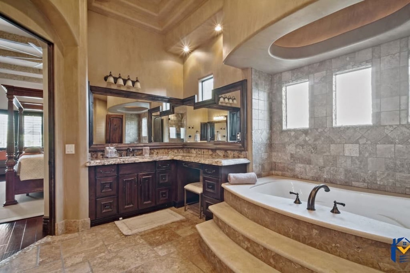 Indulge in your private spa-like retreat with marble surfaces, soaking tub, and rich wood vanity creating the perfect luxurious escape.