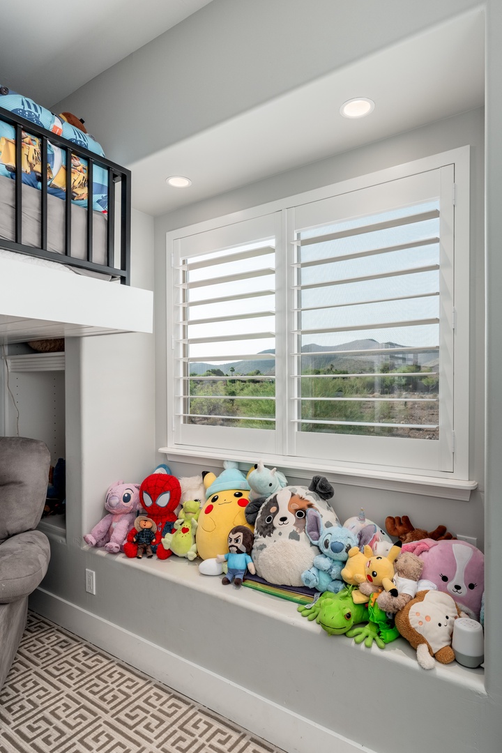Your little ones will love this cozy bunk room with a playful collection of stuffed friends and soft natural light streaming through shuttered windows overlooking peaceful mountain views.