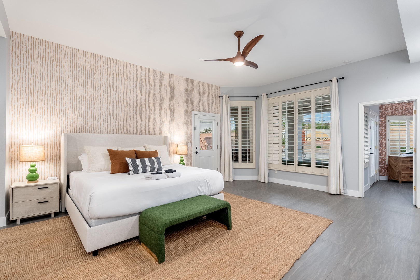 Unwind in your serene bedroom, where a plush bed, warm textures, and abundant natural light create your perfect retreat. Step outside through your private door to enjoy the pool view.