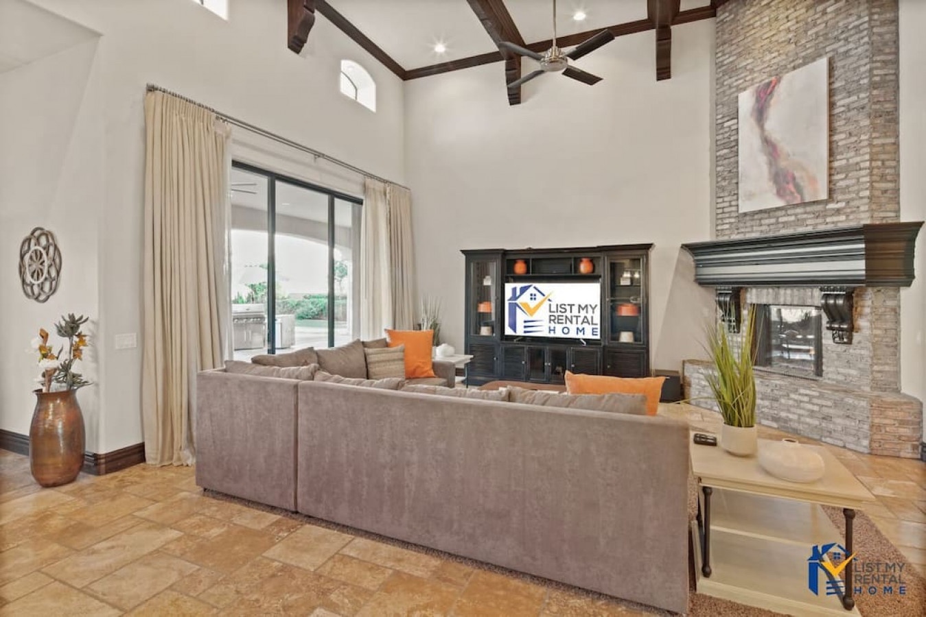 Unwind in your spacious living room featuring exposed beams, stone fireplace, and cozy sectional seating perfect for movie nights.