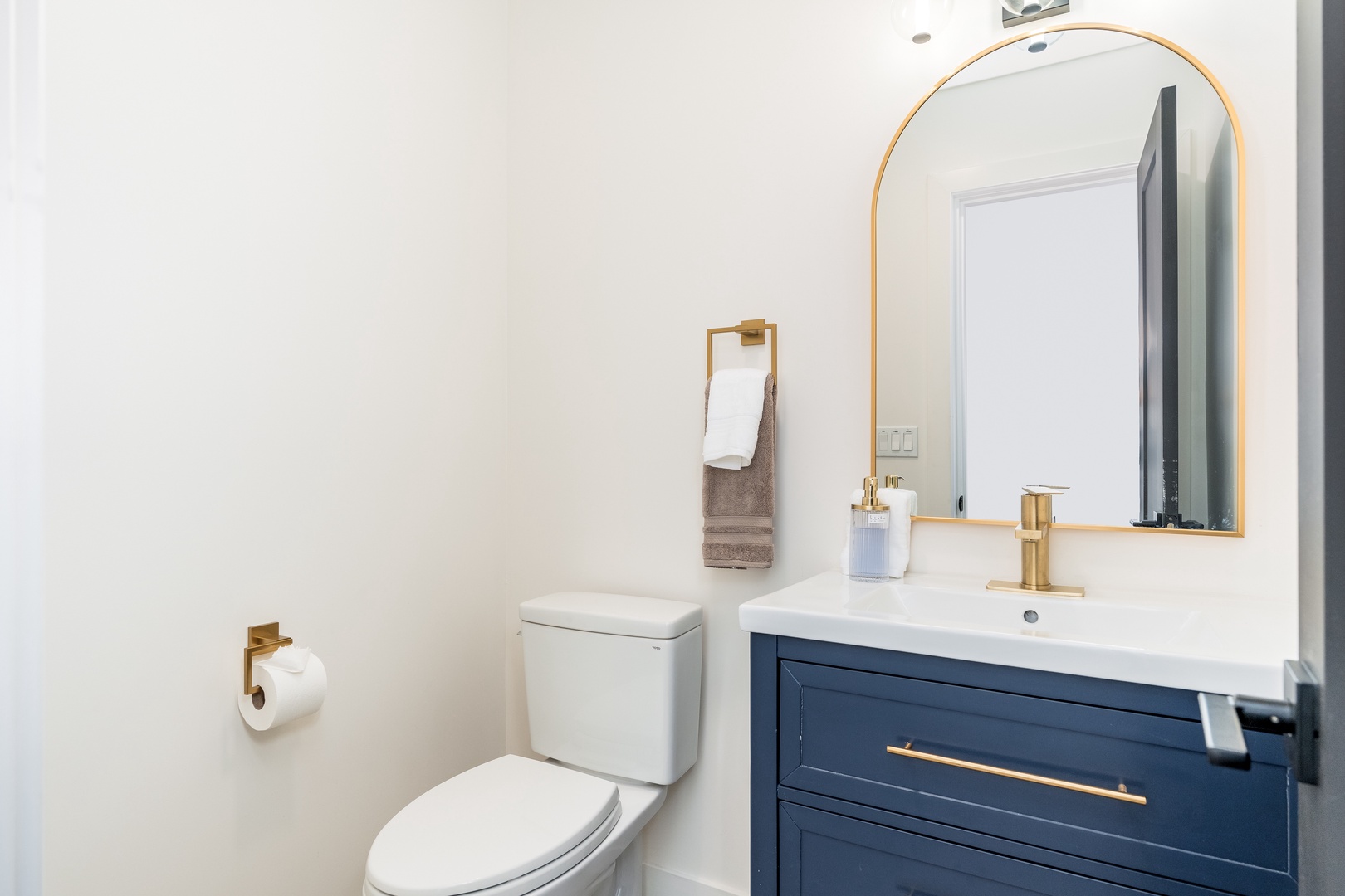 Your private bathroom blends modern style with functional comfort. Crisp white walls, a chic navy vanity with gold accents, and fresh linens create a serene space to refresh.