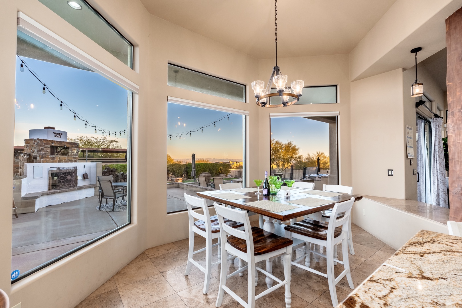 Step into your dining space where floor-to-ceiling windows frame stunning sunset views, creating the perfect backdrop for memorable meals with loved ones.