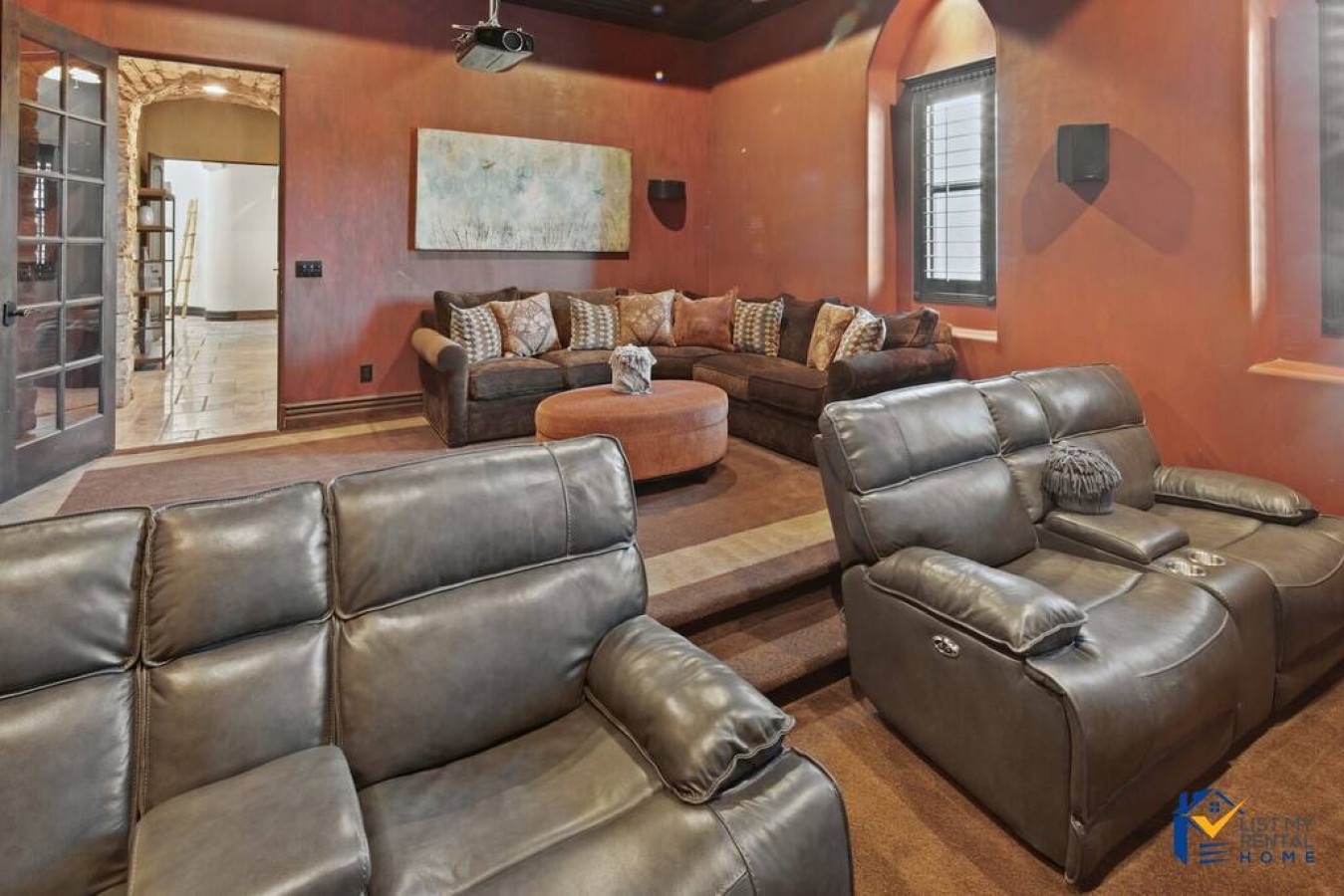 Sink into plush leather recliners in your private theater room, where warm terracotta walls create perfect ambiance for movie nights.