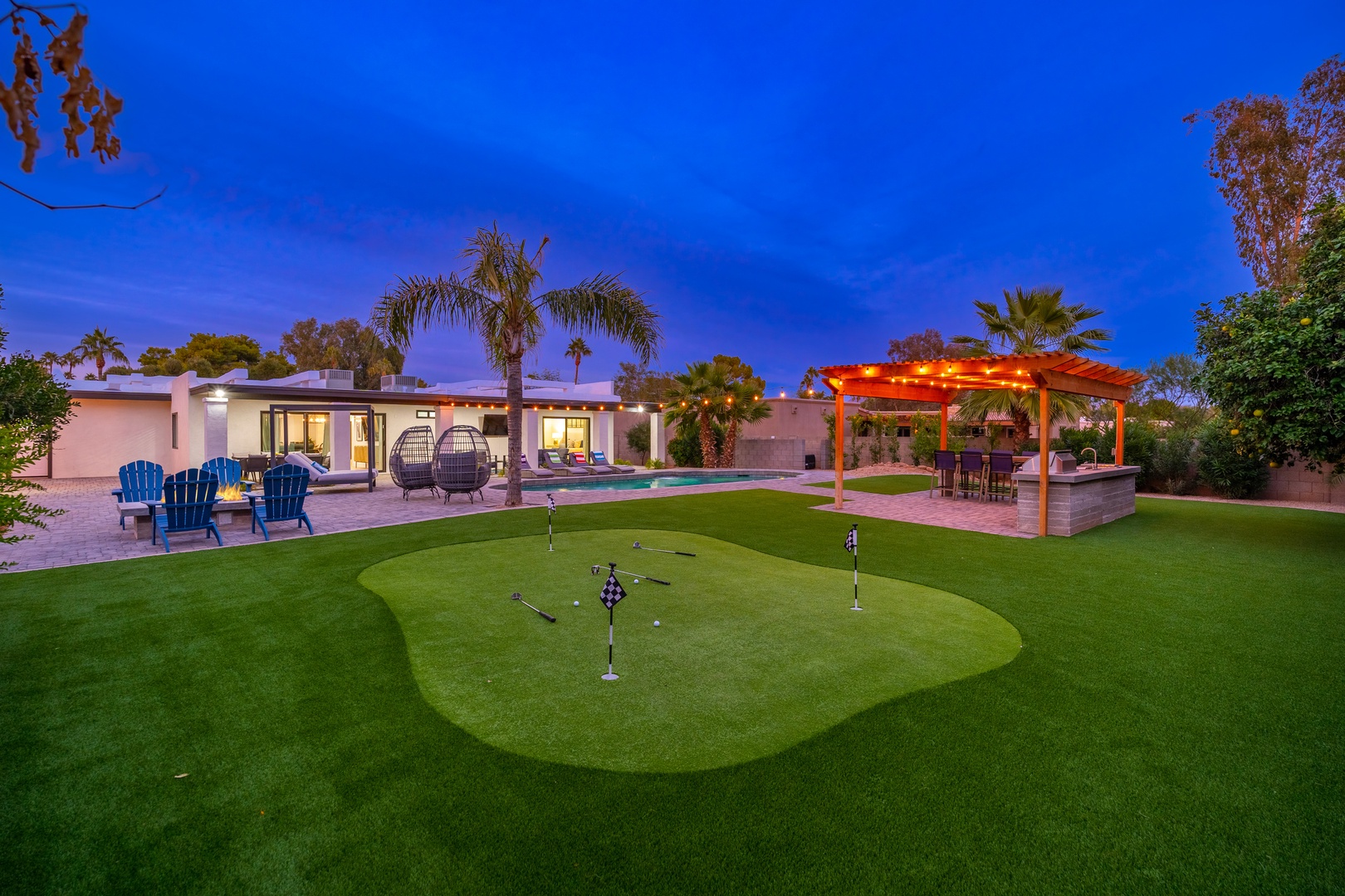 Private putting green, sparkling pool, and palm-lined patio await—perfect for practice, relaxation, and twilight evenings under desert skies.