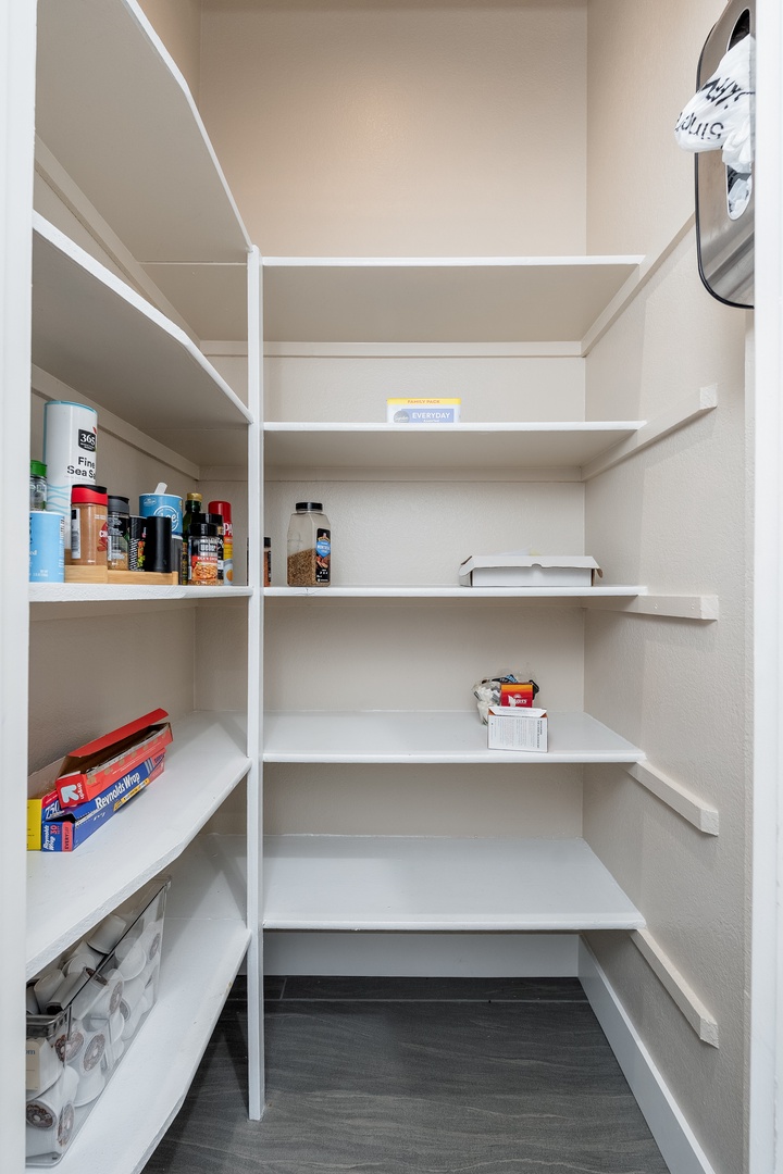 Spacious walk-in pantry with custom shelving keeps your kitchen essentials organized and your cooking supplies within easy reach.