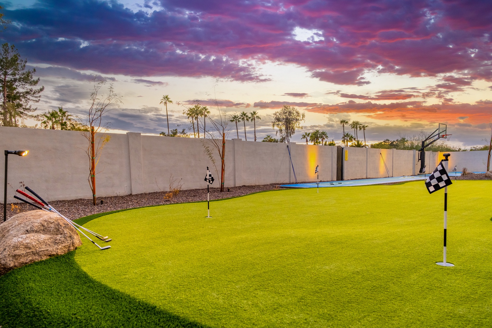 Your private putting green awaits under brilliant desert skies, perfect for perfecting your short game at sunset with palm trees swaying beyond the walls.