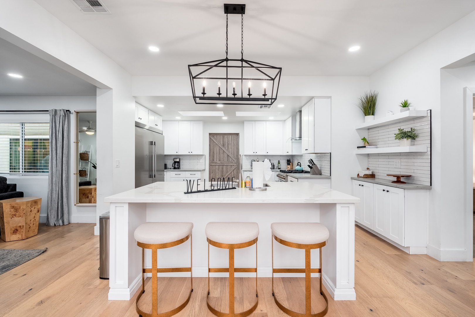 Gather around this bright, modern kitchen featuring a spacious island, crisp white cabinetry, and stylish pendant lighting—perfect for preparing meals and sharing stories during your stay.