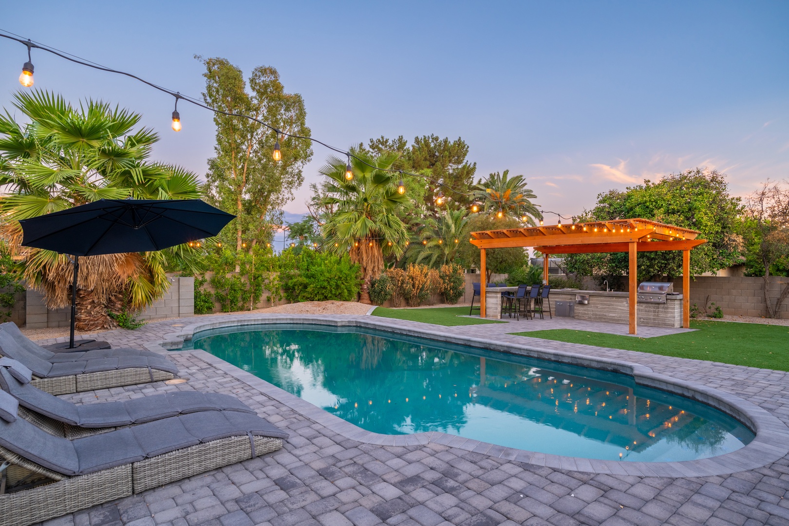 Unwind in your private backyard oasis with a sparkling pool, poolside loungers, and a covered outdoor kitchen—perfect for soaking up the Arizona sunshine and hosting unforgettable evenings under string lights.