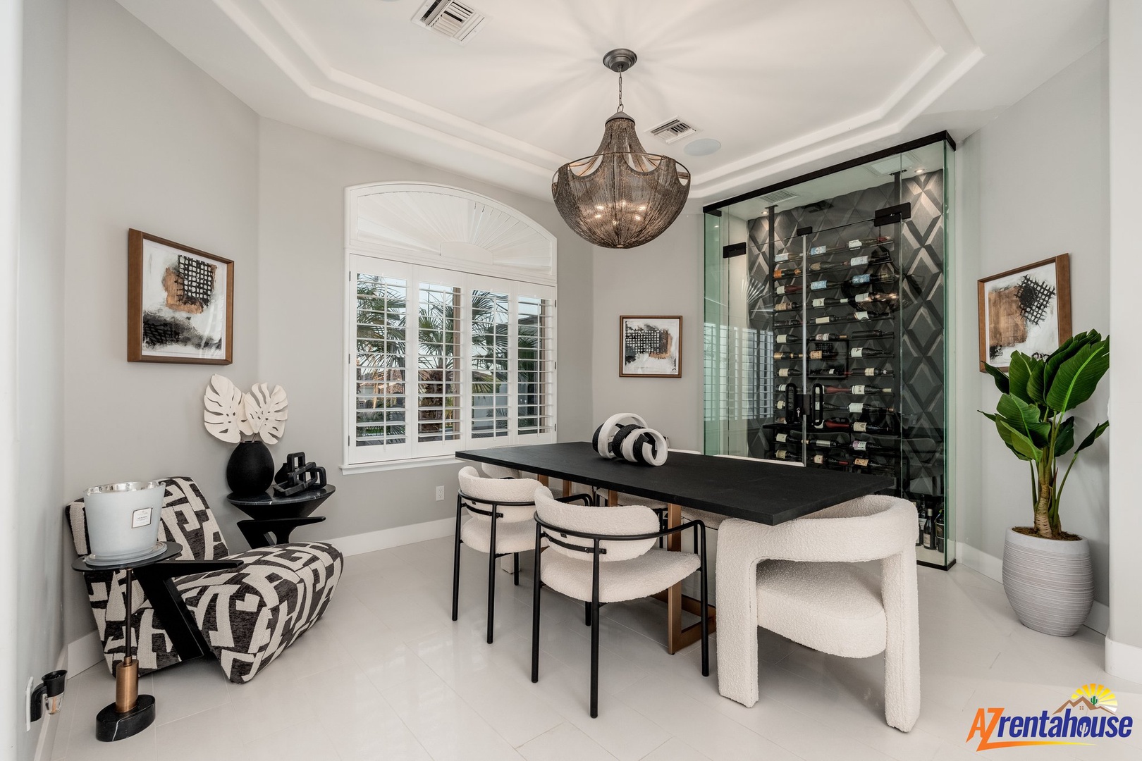 Gather around your elegant dining table beneath this stunning chandelier, with an impressive wine collection displayed behind glass.