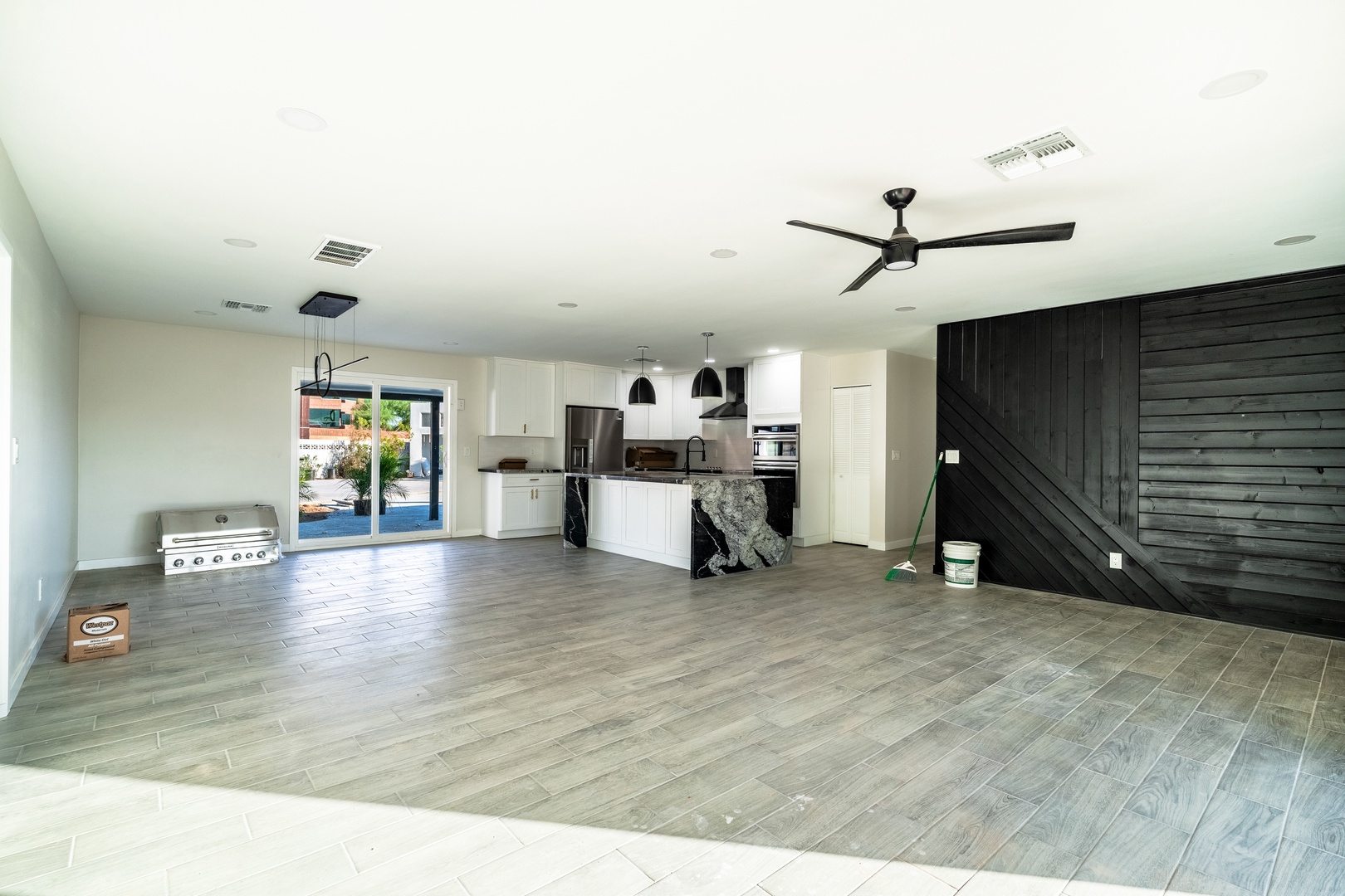Your open-concept living area flows seamlessly into a fully equipped kitchen, complete with modern appliances, a stylish island, and direct access to the outdoor patio—perfect for relaxing and entertaining.