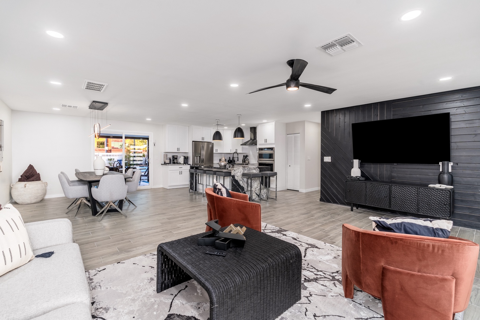 Settle into this stylish open-concept living area where modern comfort meets elegant design. Lounge on plush seating, cook in your fully-equipped kitchen, and unwind in front of the big screen—all in one seamless space.