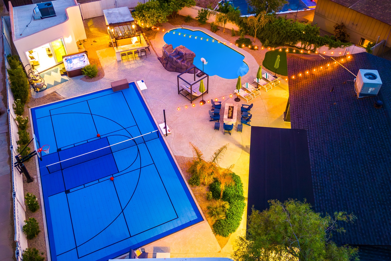 Aerial view of this property's private backyard featuring a full-size basketball court, sparkling swimming pool, hot tub, outdoor dining area, and multiple entertainment zones for active recreation and relaxation.