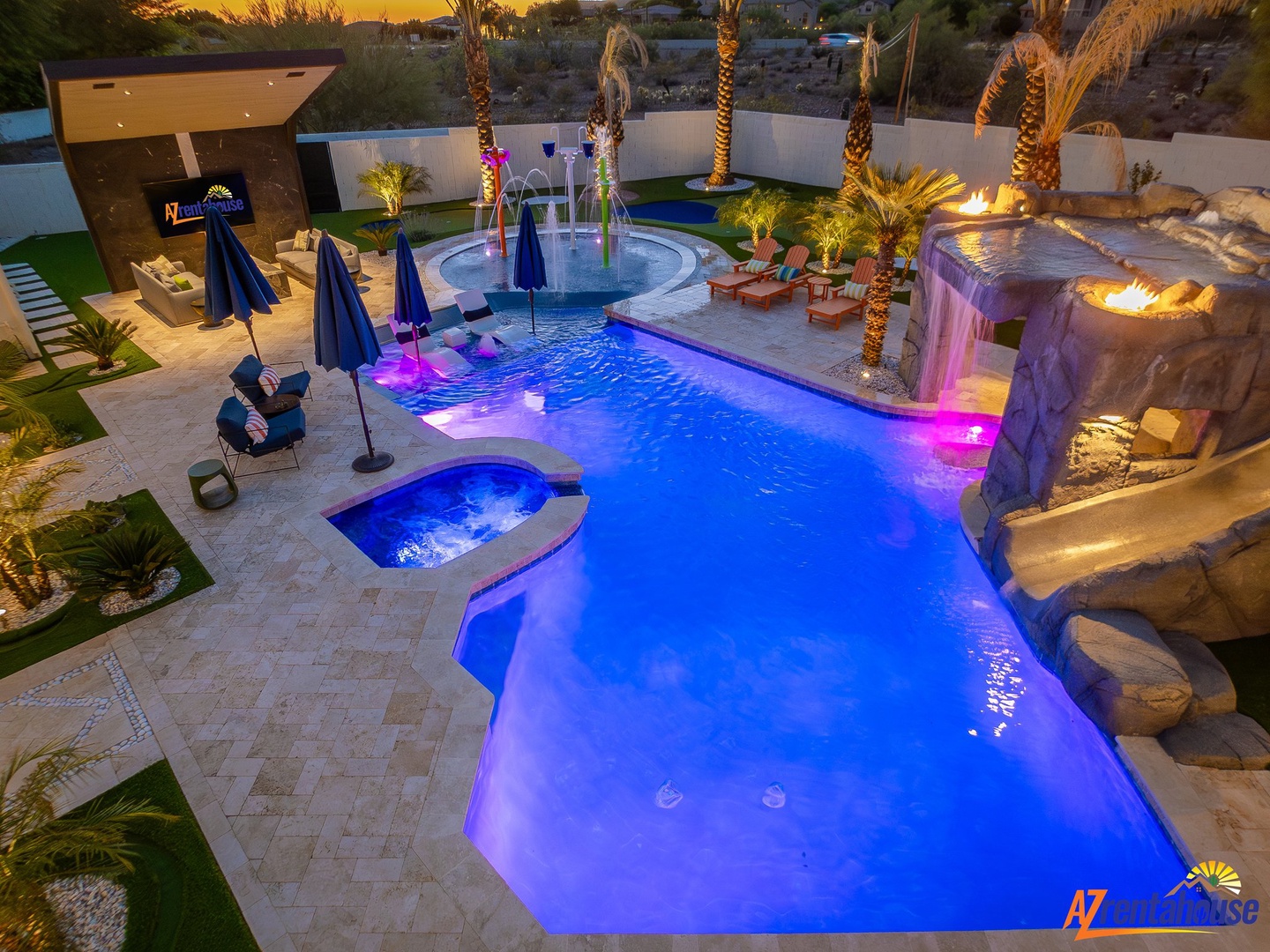 Stunning resort-style pool area with vibrant blue lighting and tropical palm trees creates the perfect evening paradise.