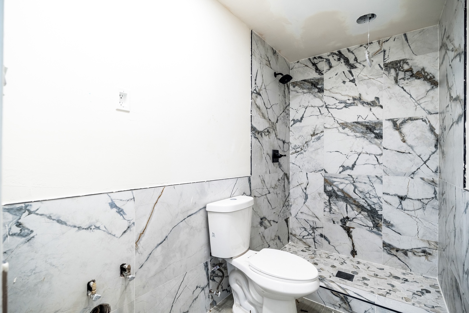 Step into your private spa-like retreat with stunning marble tile work enveloping the walk-in shower and flowing throughout the space.