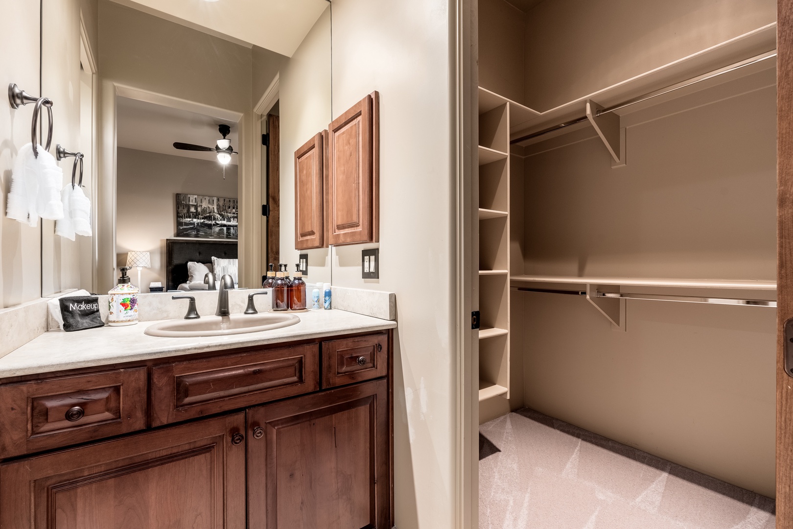 Your private bathroom offers warm wood tones, a spacious vanity, and a thoughtfully organized walk-in closet—everything you need to feel right at home during your stay.