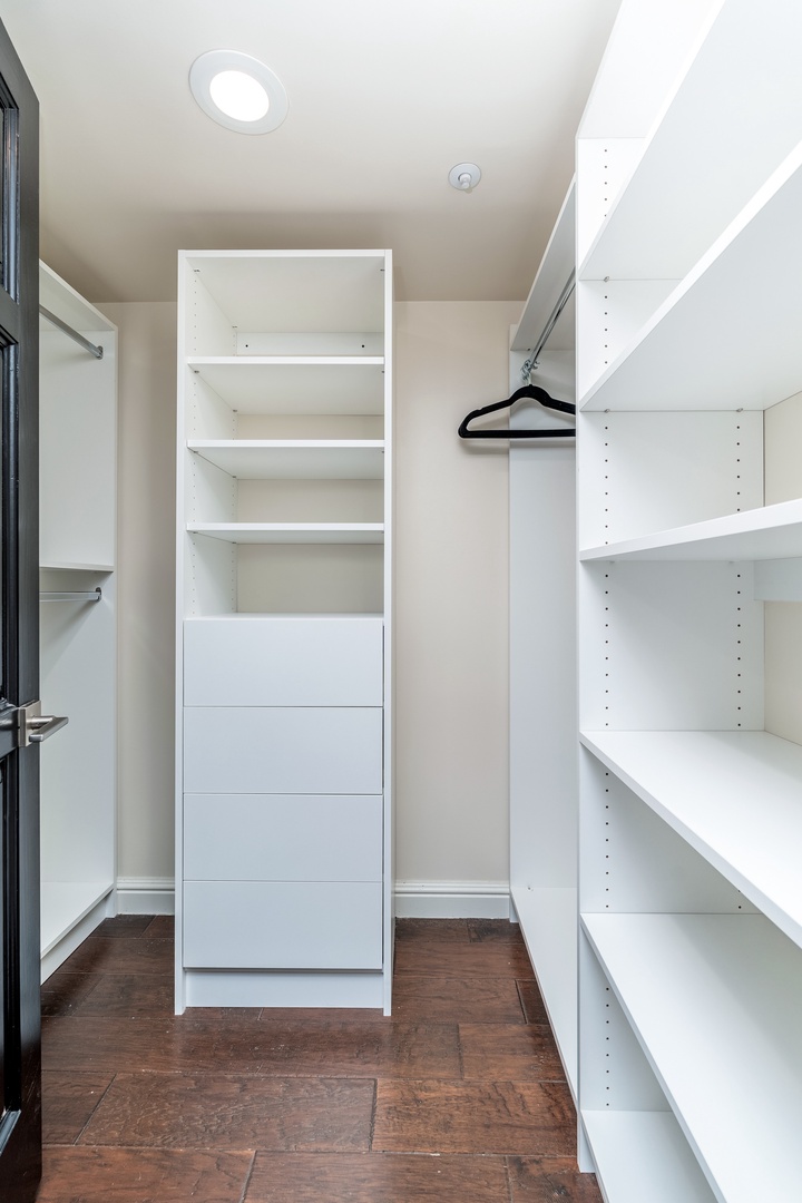Generous storage awaits in your walk-in closet, featuring built-in shelving, drawers, and hanging space to keep your wardrobe perfectly organized during your stay.