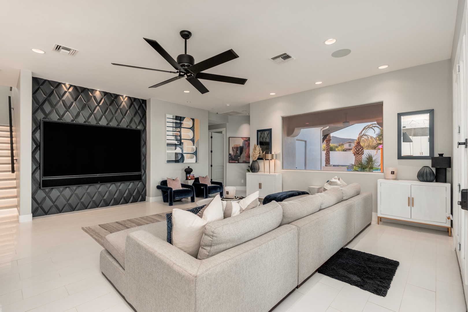 Sink into plush seating beneath a stylish ceiling fan and watch your favorite shows on the oversized flat-screen. This chic living room blends modern comfort with contemporary design, perfect for relaxing after exploring.