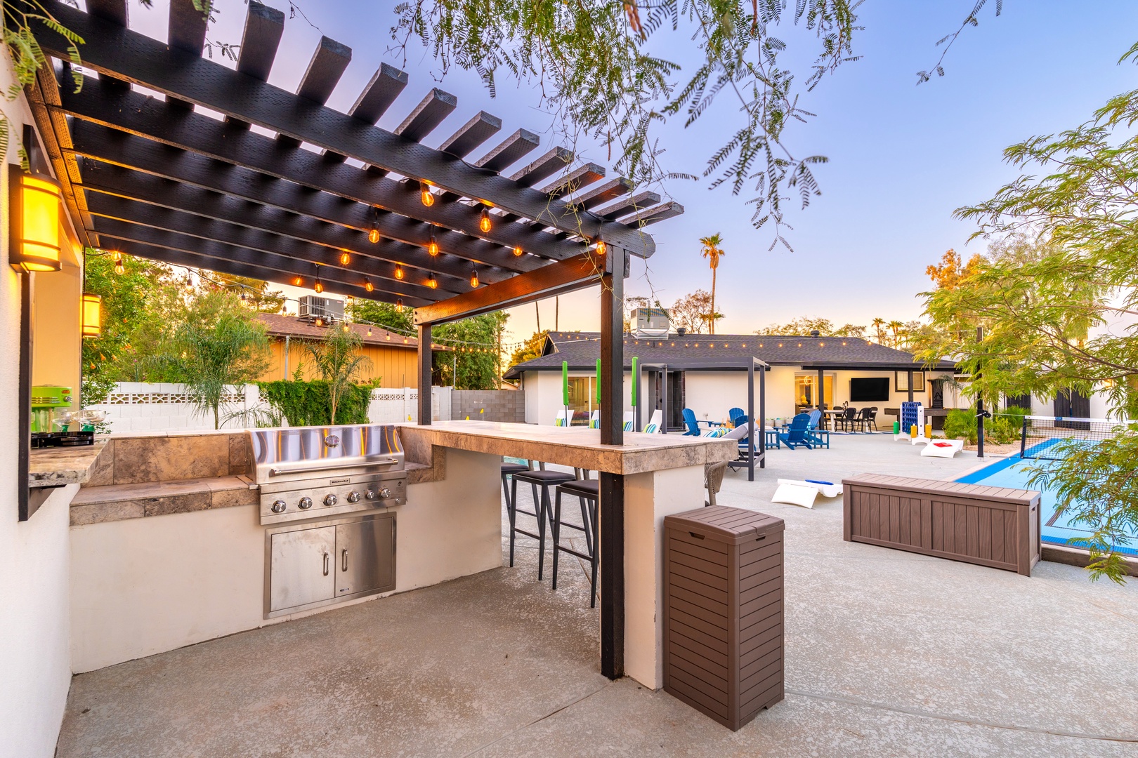 Step into your private outdoor oasis where warm string lights set the scene for unforgettable evenings grilling, dining, and relaxing by the sparkling pool under open skies.